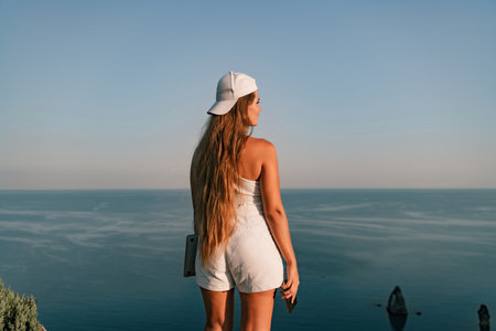 Portrait of a happy woman in a cap with long hair against the seaの写真素材