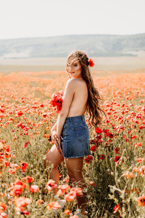 Woman poppies field. portrait happy woman with long hair in a poppy field and enjoying the beauty of nature in a warm summer day.の写真素材