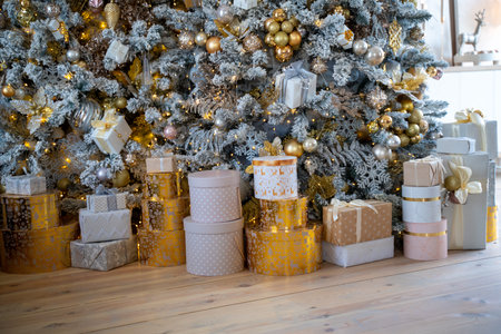 Christmas presents under the Christmas tree. New Years and Christmas. Wrapped Gift. Beautiful packaging. Ribbon and bow on the packaging.の写真素材