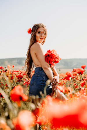 Woman poppies field. portrait happy woman with long hair in a poppy field and enjoying the beauty of nature in a warm summer day.の写真素材