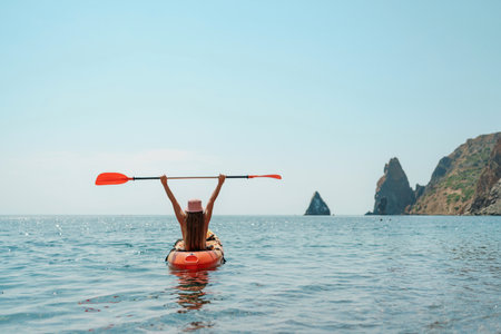 Kayak sea woman. Happy attractive woman with long hair in red swimsuit, swimming on kayak. Summer holiday vacation and travel concept.の写真素材