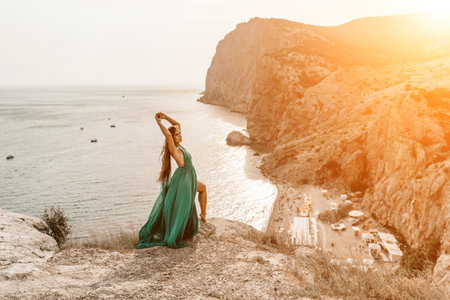 Woman sea trevel green dress. Side view a happy woman with long hair in a long mint dress posing on a beach with calm sea bokeh lights on sunny day. Girl on the nature on blue sky background.の写真素材