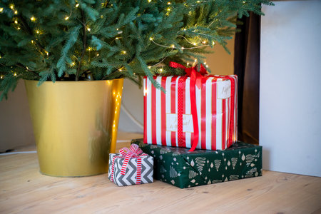 Christmas presents under the Christmas tree. New Years and Christmas. Wrapped Gift. Beautiful packaging. Ribbon and bow on the packaging.の写真素材
