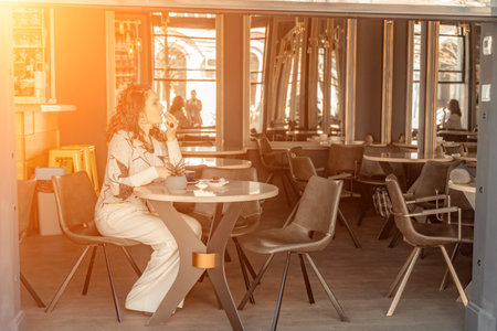 Woman cafe coffee breakfast. Portrait of an adult beautiful woman in an elegant suit in a cafeの写真素材