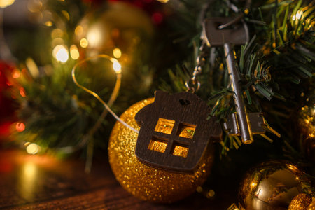 Gift key house with a keychain backdrop of Christmas tree. Building, design, project, moving to new house, mortgage, rent and purchase real estate. A gift for New Year, Christmasの写真素材