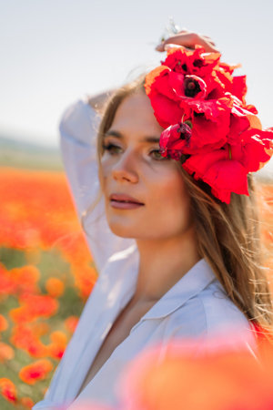 Woman poppies field. Side view of a happy woman with long hair in a poppy field and enjoying the beauty of nature in a warm summer day.の写真素材
