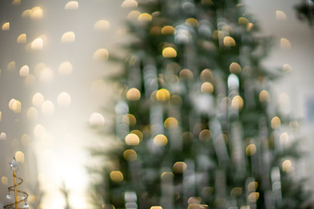 Close-up of a festively decorated outdoor Christmas tree with balls on a blurred sparkling fairy...
