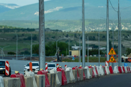 Red, white plastic safety barriers along road. Ensuring road safety with visible barriers. Effective...