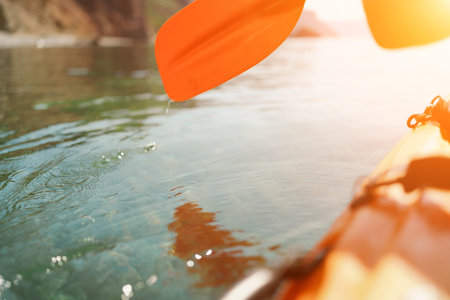 Kayak paddle sea vacation. Person paddles with orange paddle oar on kayak in sea. Leisure active...