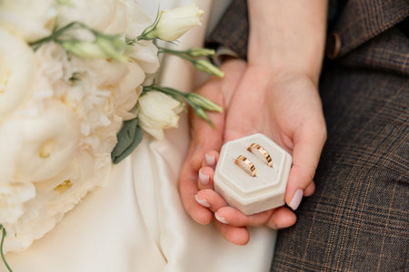 A couple holding a white box with two rings inside