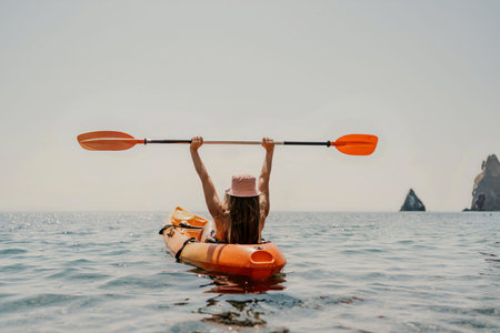 Kayak sea woman. Happy attractive woman with long hair in red swimsuit, swimming on kayak. Summer holiday vacation and travel concept.の写真素材