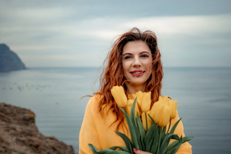 Portrait of a happy woman with hair flying in the wind against the backdrop of mountains and sea....