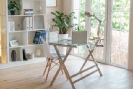 Comfortable workplace with a laptop in the office, at home. Bright room with large windows,...