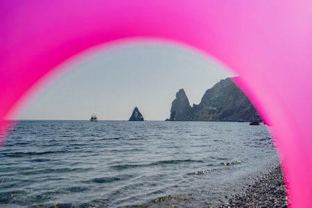 A pinkish purple arch is seen over the ocean