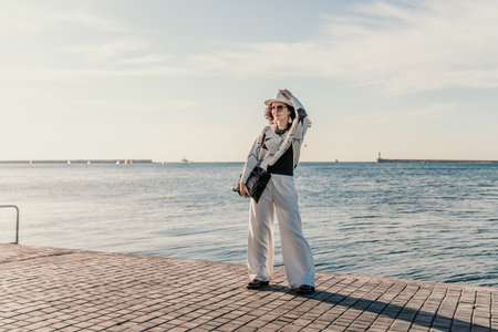 Stylish seashore woman. Fashionable woman in a white hat, whiteの写真素材