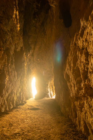 A cave with a small opening in the wall. The light shining through the opening creates a warm and inviting atmosphere.の写真素材