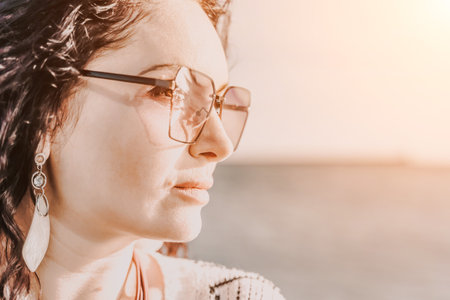 Portrait of a curly woman in glasses on the background of the seの写真素材