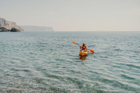 Kayak sea woman. Happy attractive woman with long hair in red swimsuit, swimming on kayak. Summer holiday vacation and travel concept.の写真素材