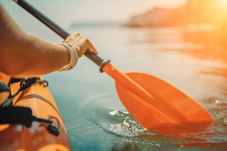 Kayak paddle sea vacation. Person paddles with orange paddle oar on kayak in sea. Leisure active lifestyle recreation activity rest tourism travelの写真素材