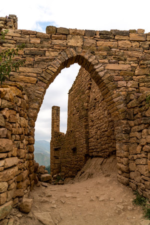 A stone archway with a small window in the middleの写真素材