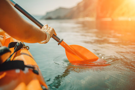 Kayak paddle sea vacation. Person paddles with orange paddle oar on kayak in sea. Leisure active lifestyle recreation activity rest tourism travelの写真素材