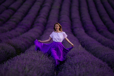 Lavender Field Woman Purple Skirt - A woman in a purple skirt smiles while walking through a field of lavender flowers.の写真素材
