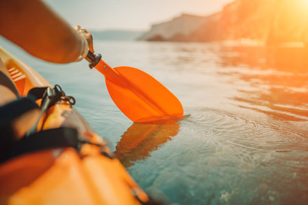 Kayak paddle sea vacation. Person paddles with orange paddle oar on kayak in sea. Leisure active lifestyle recreation activity rest tourism travelの写真素材