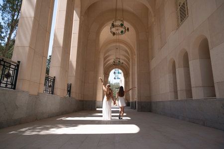 Armenian Church Women Tourists Yerevan - Two women wearing white dresses stand in the courtyard of a church in Yerevan, Armenia, enjoying the beautiful architecture and sunny weather.の写真素材