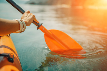 Kayak paddle sea vacation. Person paddles with orange paddle oar on kayak in sea. Leisure active lifestyle recreation activity rest tourism travelの写真素材