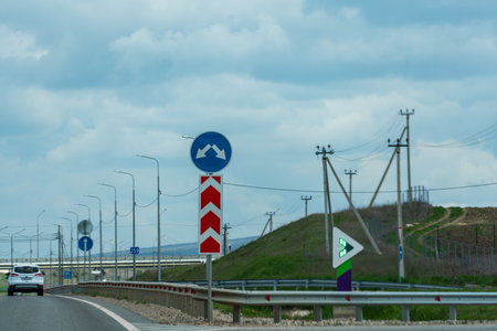 A road with a blue sign that says "Do not enter" and a red arrow pointing to the left.の写真素材