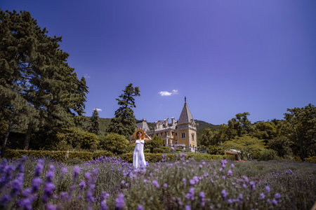 A woman is standing in a field of purple flowersの写真素材