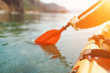 Kayak paddle sea vacation. Person paddles with orange paddle oar on kayak in sea. Leisure active...