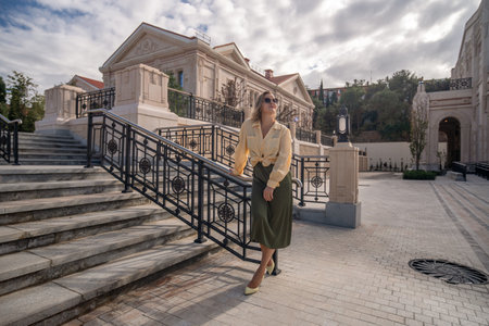Woman Fashion Skirt Stairs - Woman in a stylish outfit poses on stairs in front of a classic building.の写真素材