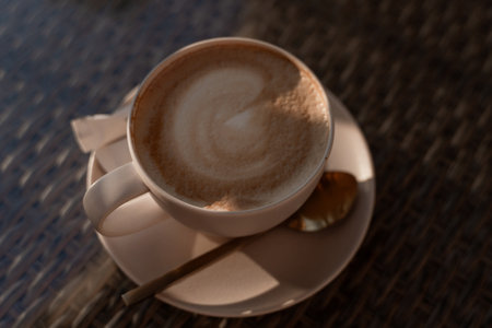 Coffee Latte Cup Saucer - Close-up image of a cup of latte on a saucer with a spoon.の写真素材
