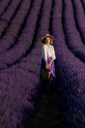 A woman is standing in a field of lavender flowersの写真素材