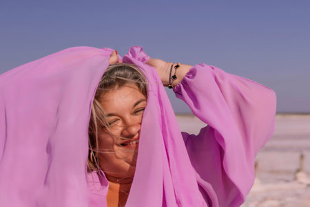 Woman Pink Scarf Salt Flats Beach Playful Portraitの写真素材
