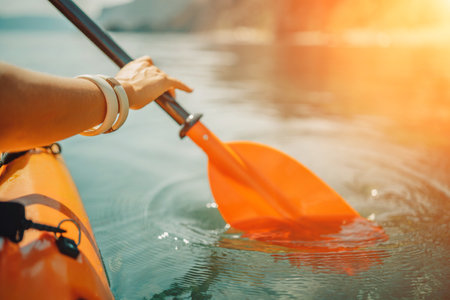 Kayak paddle sea vacation. Person paddles with orange paddle oar on kayak in sea. Leisure active lifestyle recreation activity rest tourism travelの写真素材