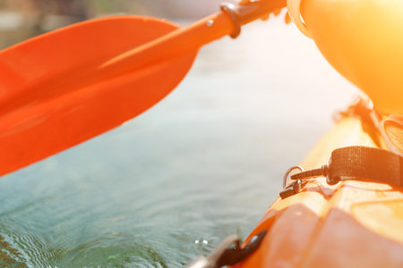Kayak paddle sea vacation. Person paddles with orange paddle oar on kayak in sea. Leisure active lifestyle recreation activity rest tourism travelの写真素材