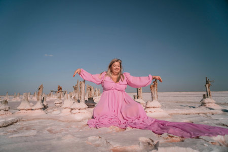 Woman Pink Dress Salt Formations Lake - A woman in a pink dress poses in front of salt formations in a lake.の写真素材