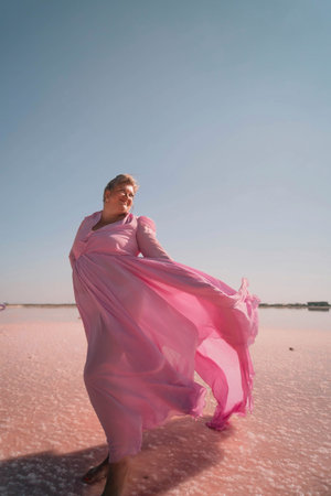 Woman Pink Dress Pink Lake - Woman in a pink dress stands on a pink lake with her dress billowing in...
