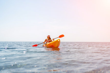 Kayak sea woman. Happy attractive woman with long hair in red swimsuit, swimming on kayak. Summer holiday vacation and travel concept.の写真素材