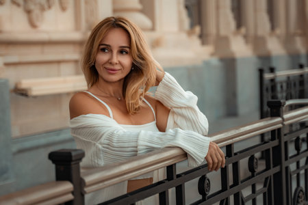 Woman Blonde Hair White Cardigan Leaning Railing Building Streetの写真素材