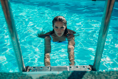 woman swimming pool. happy woman with wet hair sunbathing in pool