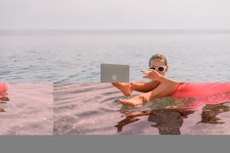 Freelance close up woman hands writing on computer. Well looking middle aged woman typing on laptop keyboard outdoors with beautiful sea view.の写真素材