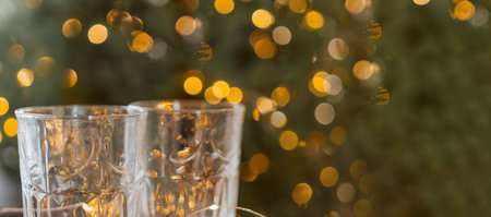 Champagne glasses, New Year decor. New Years festive setting, family holidays.Two glasses of champagne are on the table against the background of New Years decorated tree.の写真素材