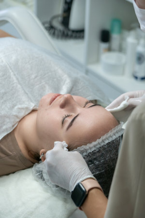 Facial Treatment, Skincare Clinic, Woman Relaxation: Professional facial cleansing procedure, modern spa, present day.の写真素材