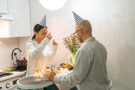 Couple Birthday Celebration Kitchen: Intimate birthday party for a couple in their modern kitchen, celebrating with cake and small snacks.の写真素材