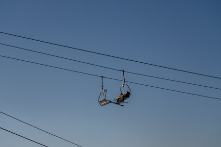 Chairlift Riders Transportation Mountains: Evening Aerial View showcasing passengers ascending mountain via chairlift.の写真素材
