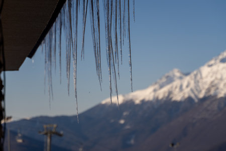 Icicles, Mountains, Winter: Freezing Temperatures Cause Icicle Formation on Building Roof, Mountain Viewの写真素材