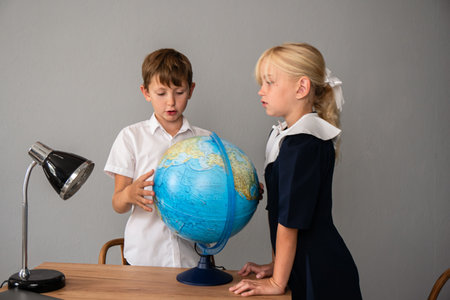 Globe Children Classroom Learning - A boy and girl in a classroom study a globe together.の写真素材